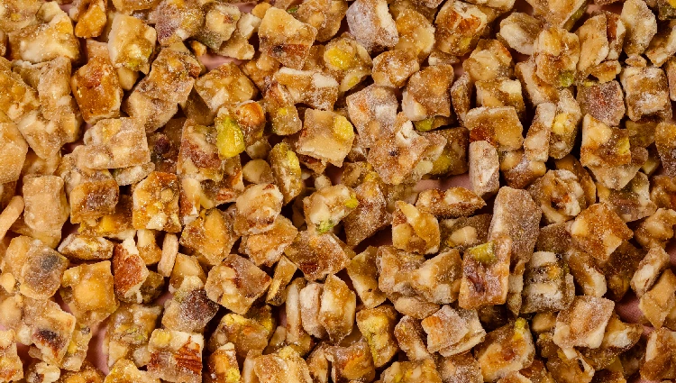 Mix fruit 1 A wooden bowl filled with Mix Nut Crunch, a blend of almonds, cashews and pistachios used as toppings for ice cream and premium desserts.