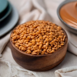 A wooden bowl filled with crunchy butterscotch nuts used as ice cream toppings.