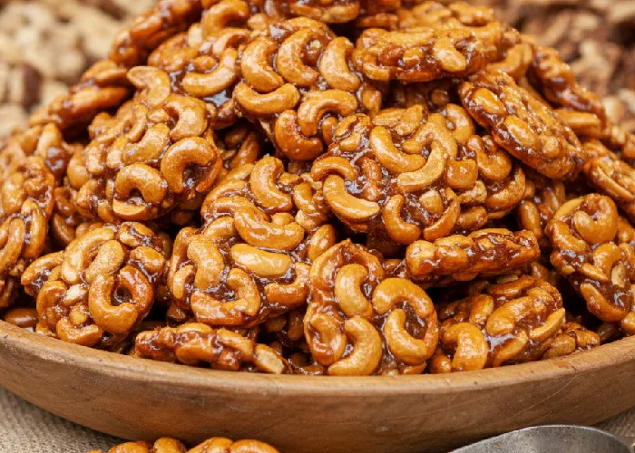 Cashew pralines displayed in bulk showing their glossy caramel coating and premium quality.